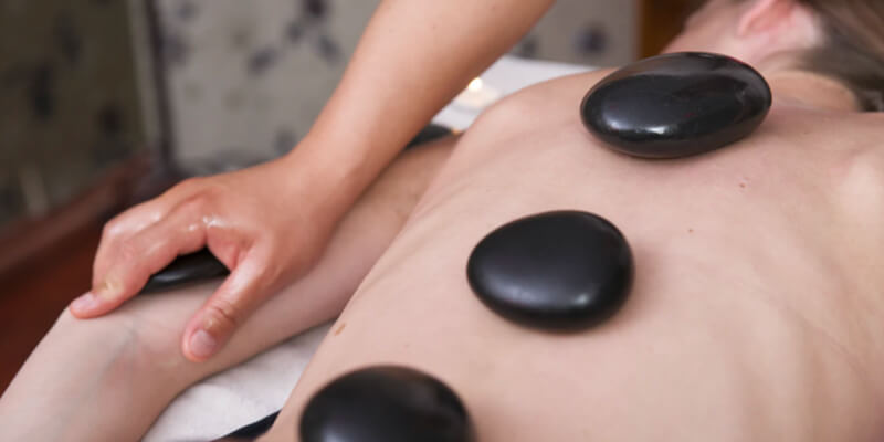 Spa treatment with hot stones on the back and arms