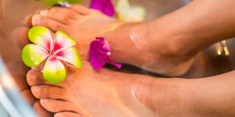 Feet immersed in water with flowers